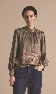 Front top half view of a woman wearing the summum leaves top with long puff sleeves.