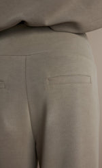 Load image into Gallery viewer, Back close up view of a woman wearing the Summum Clay Scuba Wide-Leg Sweatpant
