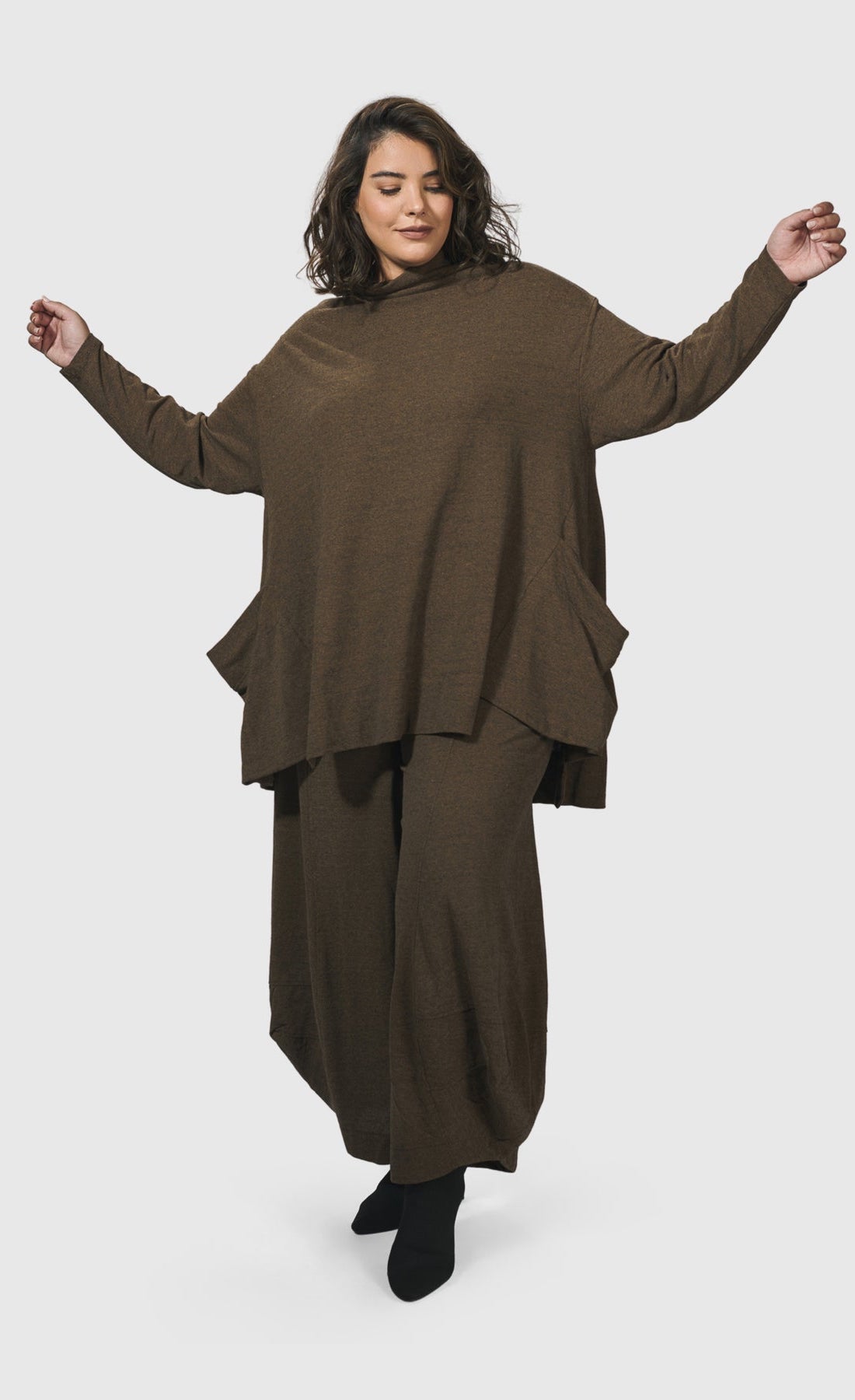 Front full body view of a woman wearing the Alembika Essential Trapeze Brown Top
