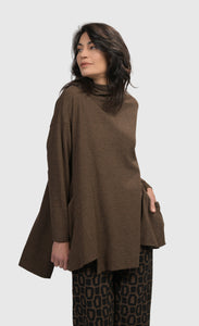 Front top half view of a woman wearing the Alembika Essential Trapeze Brown Top