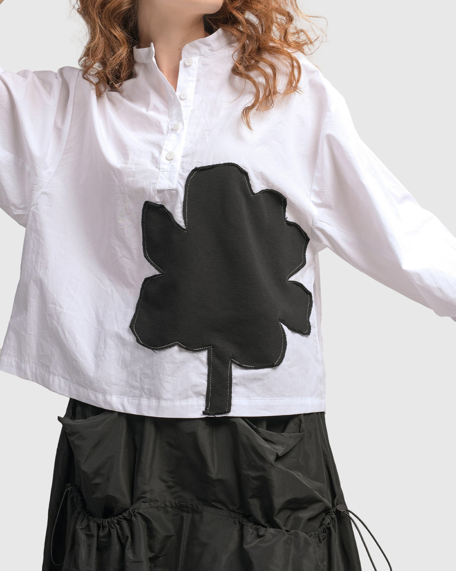 Front close up view of a woman wearing the Alembika Urban Modern Flower Top