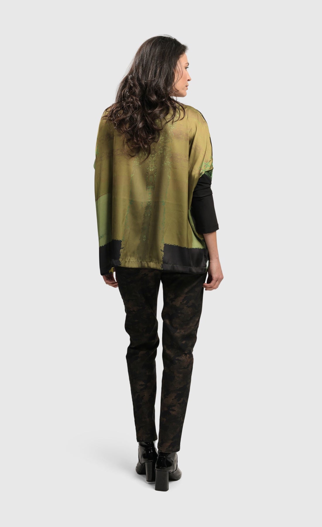 Back full body view of a woman wearing the Alembika Olive Martini Emerald Boxy Tee