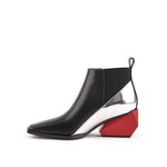 Load image into Gallery viewer, A single women's ankle boot with a black leather upper, a metallic silver side panel, a black elastic side gore, and a bold geometric red block heel, shown against a plain white background.
