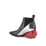 Load image into Gallery viewer, A single women's ankle boot with a black leather upper, a metallic silver side panel, a black elastic side gore, and a distinctive faceted red block heel, shown from a side profile on a white background.
