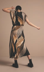 Load image into Gallery viewer, Back full body view of a woman wearing the Summum Flowy Lines Organic Print Long Skirt
