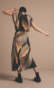 Back full body view of a woman wearing the Summum Flowy Lines Organic Print Long Skirt