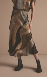 Load image into Gallery viewer, Front bottom half view of a woman wearing the Summum Flowy Lines Organic Print Long Skirt
