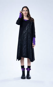 Front full body view of a woman wearing the luukaa Black Branch Dress. This dress has long sleeves, a cowl neck, an a-line silhouette, and a front glossy branch-like print running diagonally across the body.