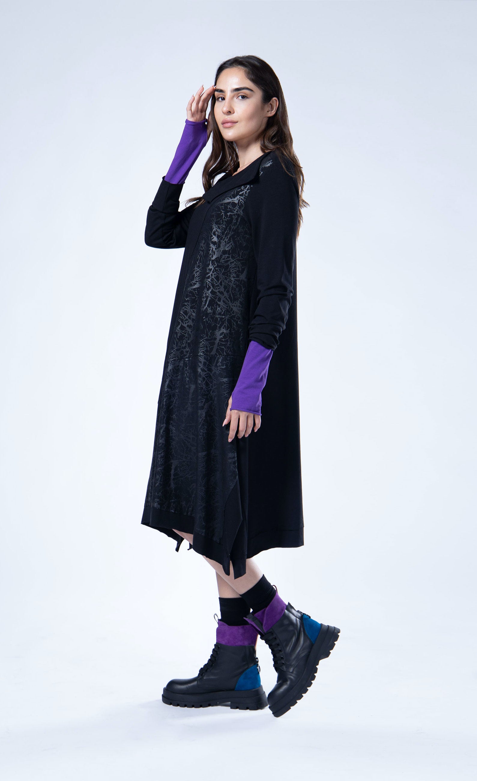 Left side full body view of the luukaa Black Branch Dress. This dress has long sleeves, a cowl neck, an a-line silhouette, and a front glossy branch-like print running diagonally across the body.