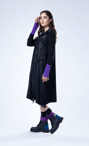 Left side full body view of the luukaa Black Branch Dress. This dress has long sleeves, a cowl neck, an a-line silhouette, and a front glossy branch-like print running diagonally across the body.