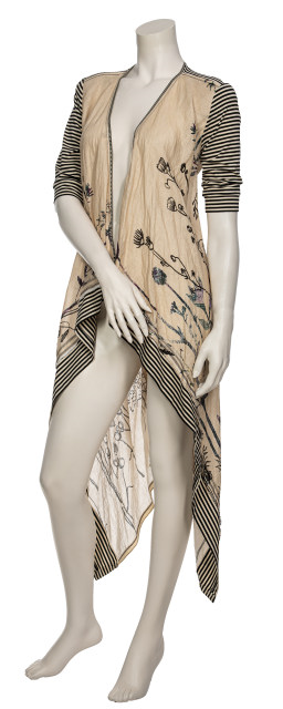Front full body view of a mannequin wearing black pants, a black tank, and the Beate Heymann Linen Wrap/Cardi. This wrap is cream colored with floral print. The sleeves and hem are black and white striped.