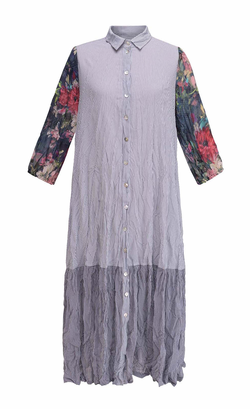 Front view of a woman wearing the alembika flora dress. This dress has navy and white striping, a button down front, and floral 3/4 sleeves. The bottom 1/4 of the dress is more transparent than the top 3/4.