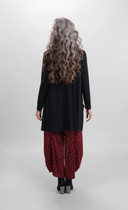 Back full body view of a woman wearing Alembika red pants and the Alembika Pocket Top in black. The back hem is longer.