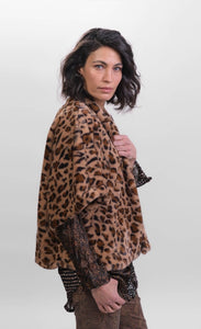 Right side top half view of a woman wearing the Alembika kenya kimono in a brown cheetah print. This kimono has a single front button, short sleeves, and a fuzzy appearance.