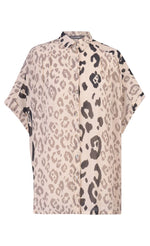Load image into Gallery viewer, Front view of the alembika Cheetah Print Button Down Top. This top has different panels of black and taupe cheetah print on a creme background. The top has a button down front and short dolman sleeves.
