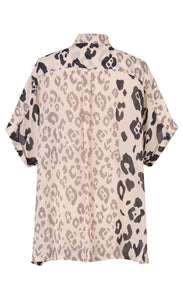 Back view of the alembika Cheetah Print Button Down Top. This top has different panels of black and taupe cheetah print on a creme background. The top has short dolman sleeves and a back pleat. 