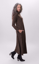 Load image into Gallery viewer, Right side full body view of a woman wearing the alembika chiu swing dress. This dress is brown with black cheetah print. It has long sleeves and a turtleneck.
