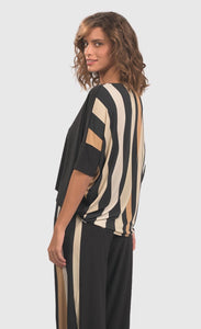 Back top half view of a woman wearing the alembika drapey dolman sunrise top. This top is black in the front and striped in the back with white and tan stripes. The top has elbow-length sleeves.