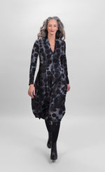 Load image into Gallery viewer, Front full body view of a woman wearing the alembika echo swing dress. This dress is grey, black, and blue tie dye with black dots all over it. It has a v-neck, a balloon skirt, and long sleeves.
