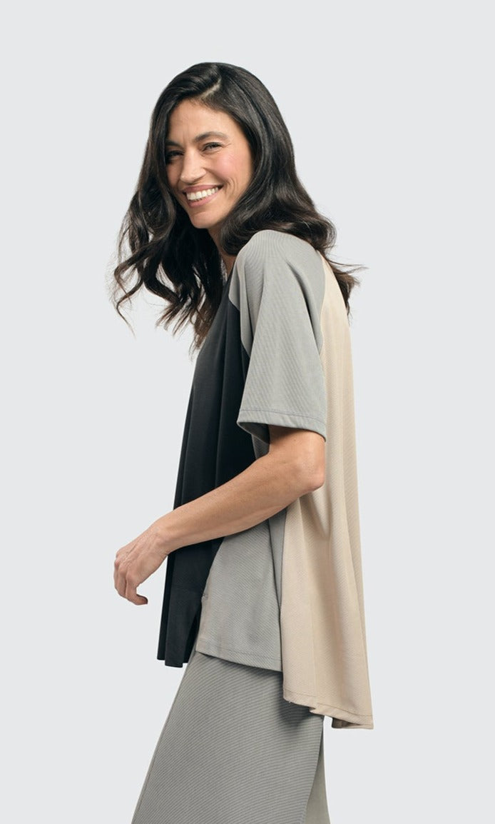 Left side top half view of a woman wearing the alembika essential colorblock cupro trapeze top
