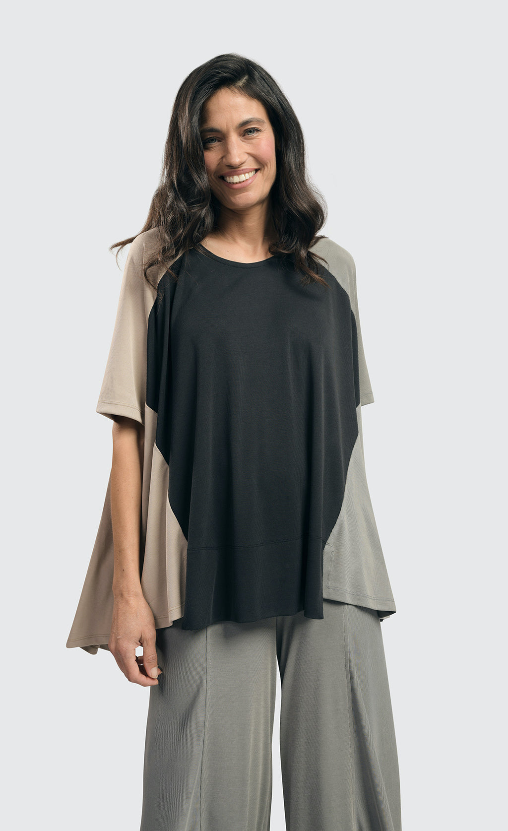 Front top half view of a woman wearing the alembika essential colorblock cupro trapeze top