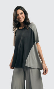 Front top half view of a woman wearing the alembika essential colorblock cupro trapeze top
