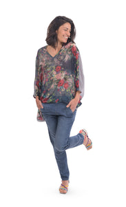 Front full body view of a woman wearing jeans and the alembika flora top. This top has a floral print on the front, an oversized fit, a v-neck, and 3/4 length sleeves.