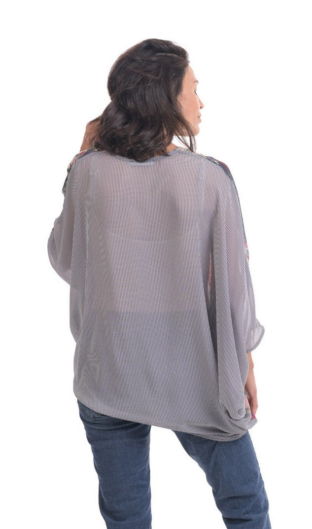 Back top half view of a woman wearing jeans and the alembika flora top. This top has blue and white striping on the back, an oversized fit, and 3/4 length sleeves.