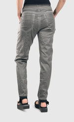 Load image into Gallery viewer, back bottom half view of a woman wearing the alembika iconic stretch jeans in a pinstripe black and white print. This pant has two back pockets, and a relaxed slim leg.
