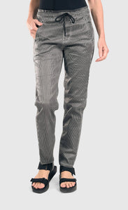 front bottom half view of a woman wearing the alembika iconic stretch jeans in a pinstripe black and white print. This pant has a drawstring waistband with a tie, two front pockets, and a relaxed slim leg.