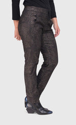 Load image into Gallery viewer, Bottom half right side view of a woman wearing the alembika iconic stretch pant in the color sepia. The pant is dark brown/black with a small metallic-like animal print. It also has a drawstring and tie waistband.

