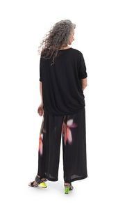 Back full body view of a woman wearing the alembika jersey with garden print block top. This top is black with 3/4 length sleeves and a relaxed fit.
