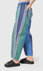 Load image into Gallery viewer, left side bottom half view of a woman wearing the alembika ocean stripes 4-pocket trousers.
