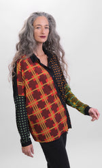 Load image into Gallery viewer, Front top half view of a woman wearing black pants and the alembika multi check blouse. This blouse has a mix of plaid and checkered prints on the front, a button up front, and dolman long sleeves..
