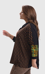 Load image into Gallery viewer, Left side top half view of a woman wearing brown pants and the alembika multi check blouse. This blouse has a mix of plaid and checkered prints on the front, a button up front, and dolman long sleeves..
