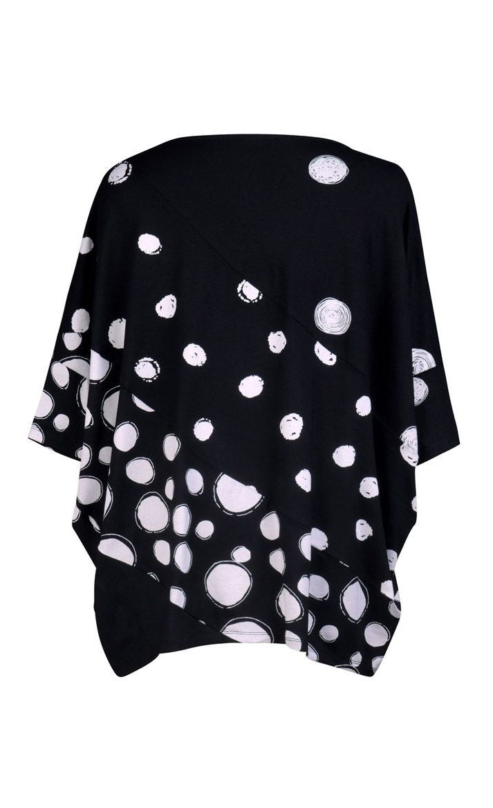 Back view of the alembika multi spotted lia jersey top. This top is black with different types of white spots all over it. The sleeves are 3/4 length and the shirt has an oversized fit.
