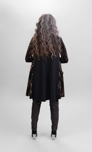 Back full body view of a woman wearing the alembika nala velvet jacket in leopard print. The jacket sits below the hips. The back of the jacket is solid back.