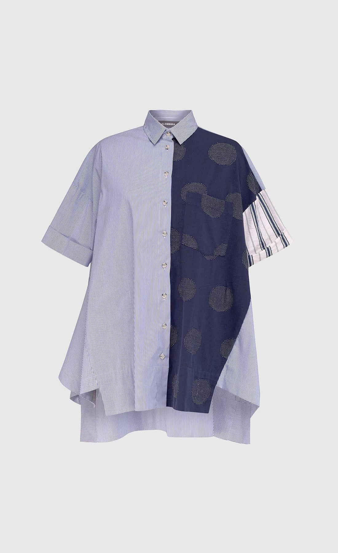 Front view of the alembika navy short sleeve shirt. This shirt has blue and white stripes on the front right side and blue with green dots on the left side.