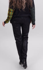 Load image into Gallery viewer, Back bottom half view of a woman wearing the Alembika Onyx Pant. This pant is black with a shiny snakeskin print on it. It has a drawstring waistband, slim legs, and two slanted side pockets.
