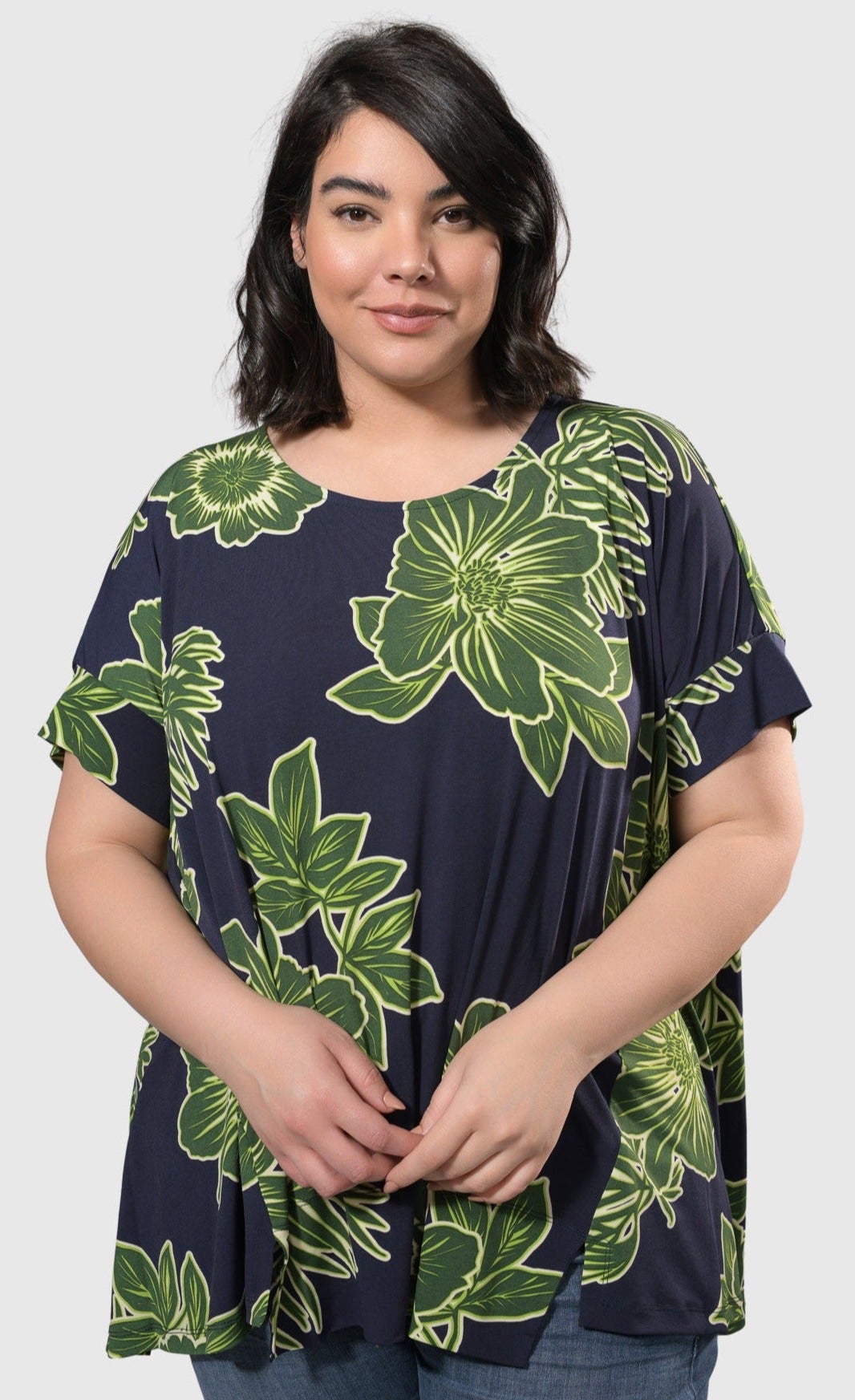 Front top half view of a woman wearing the alembika royal/green hula hi-lo swing top