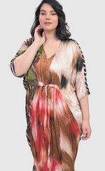 Load image into Gallery viewer, Front top half view of a woman wearing the alembika skye caftan butterfly dress. This dress has pink flowers over a brown backdrop on the right side, a pink and brown tie dye print in the center, a beige and brown tie dye print on the left side, and a black and white striped print on the back.
