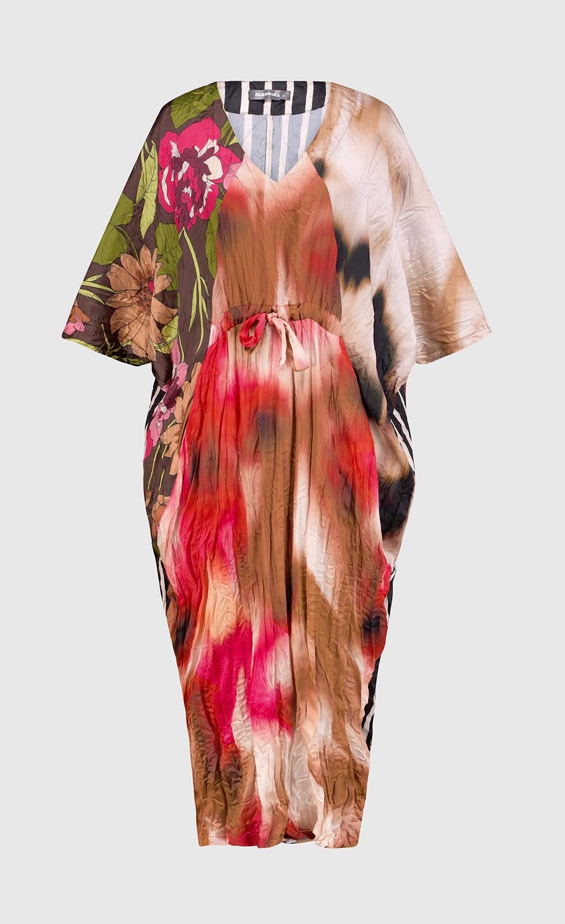 Front view of the alembika skye caftan butterfly dress. This dress has pink flowers over a brown backdrop on the right side, a pink and brown tie dye print in the center, a beige and brown tie dye print on the left side, and a black and white striped print on the back.