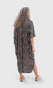 Back full body view of a woman wearing the alembika skye caftan butterfly dress. This dress is long and has black and white striping on the back.