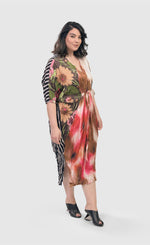 Load image into Gallery viewer, Front right side full body view of a woman wearing the alembika skye caftan butterfly dress. This dress has pink flowers over a brown backdrop on the right side, a pink and brown tie dye print in the center, a beige and brown tie dye print on the left side, and a black and white striped print on the back.
