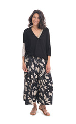 Load image into Gallery viewer, Front full body view of a woman wearing the alembika speckle mandala wide pant and the alembika colorblock top in black multi. The pant has a tie dye black and white print and wide legs.
