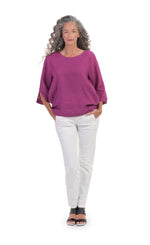Load image into Gallery viewer, Front full body view of a woman wearing a pink top and the alembika stretch denim pant. This pant is white with two front slant pockets and a drawstring waistband. The pants have a relaxed skinny silhouette.
