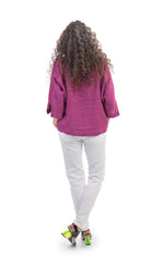 Load image into Gallery viewer, Back full body view of a woman wearing a pink top and the alembika stretch denim pant. This pant is white with a relaxed skinny silhouette.
