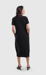 Load image into Gallery viewer, Back full body view of a woman wearing the alembika sunrise stripe dress. This dress is solid black on the back, has short sleeves, and a relaxed silhouette with a poof skirt. This dress sits mid calf level.
