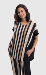 Load image into Gallery viewer, Front top half view of a woman wearing the alembika sunrise stripes swing top. This top has white stripes with a couple of tan stripes in between all of different sizes. The Top has a round neck and short sleeves. the back is solid black.
