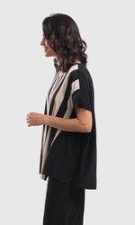 Load image into Gallery viewer, Left side top half view of a woman wearing the alembika sunrise stripes swing top. This top has white stripes with a couple of tan stripes in between all of different sizes. The Top has a round neck and short sleeves. the back is solid black.
